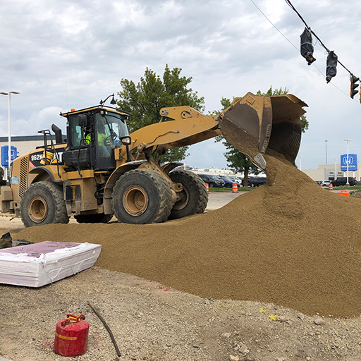 a Skid loader dumping sand