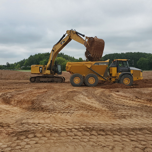 Excavator dumping dirt into a dump truck